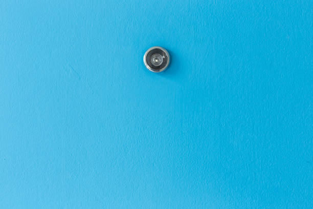 Close up door lens peephole on blue wooden texture
