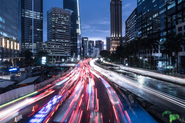Traffic rushing in Jakarta business district at night in Indonesia capital city Traffic captured with blurred motion rushing along the main avenue in Jakarta business district at night in Indonesia capital city jakarta stock pictures, royalty-free photos & images
