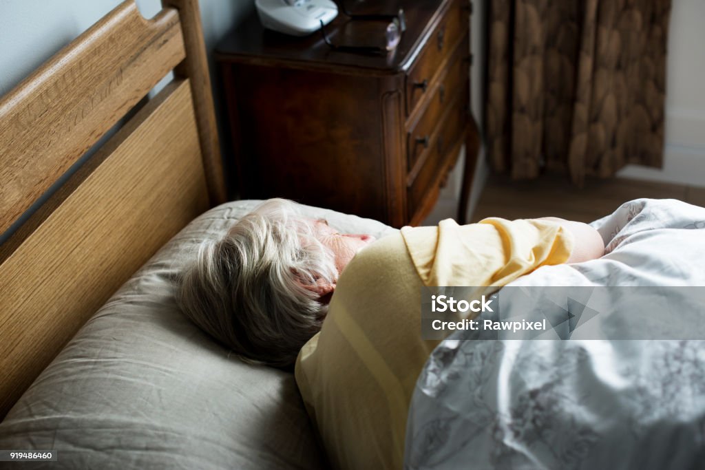 睡在床上的老年白種女人 - 免版稅老年人圖庫照片