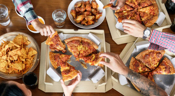 istock Friends eating pizza together at home 919489082