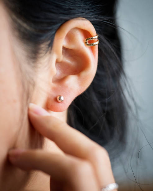 gros plan de femme &#39; oreille s avec boucles d’oreilles - perching photos et images de collection