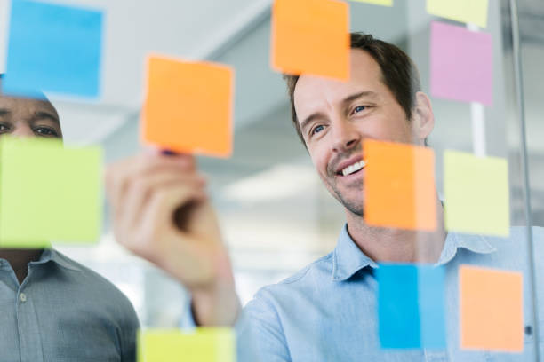 istock Businessman writing on adhesive note at glass 919504576