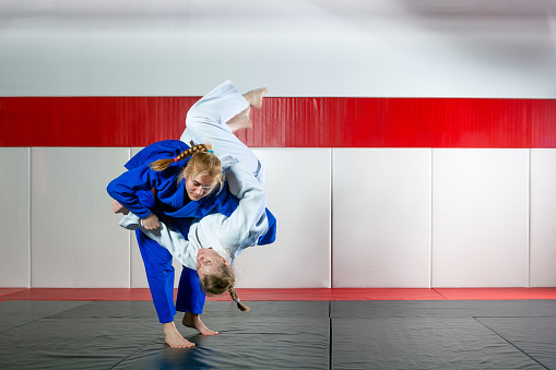 Two women fight judo on tatami