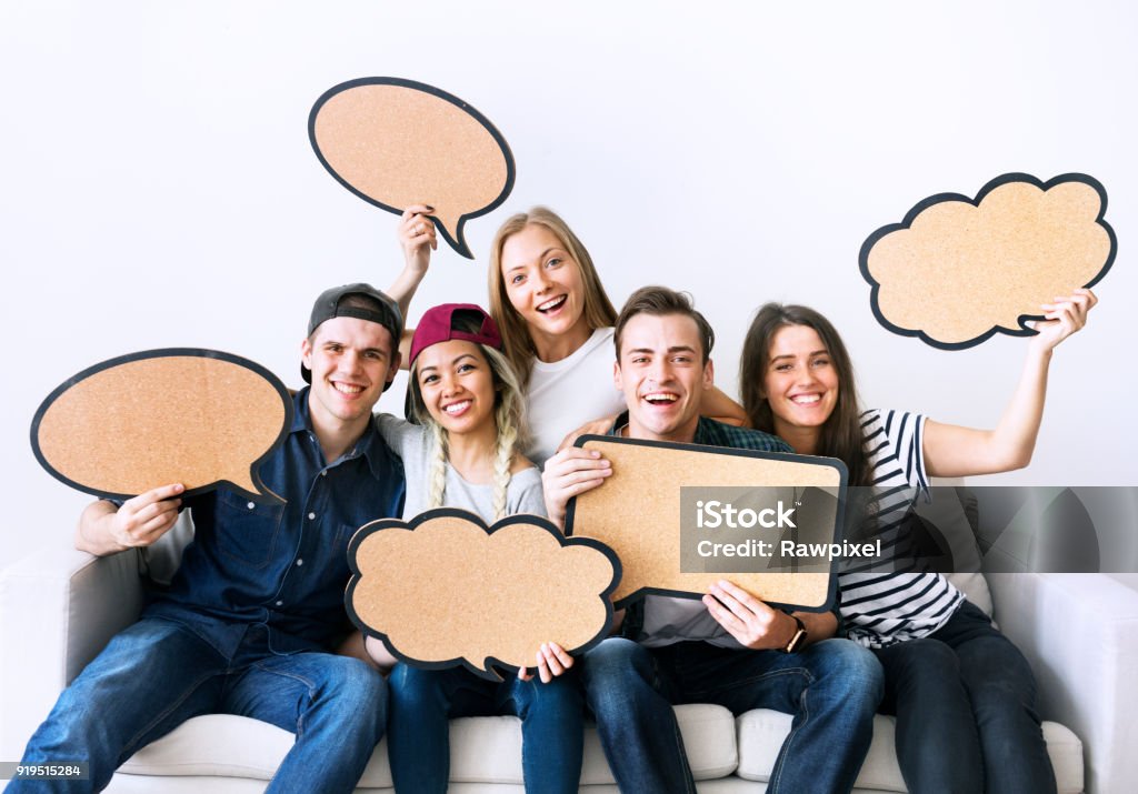 Happy young adults holding up copy-space placard thought bubbles Discussion Stock Photo