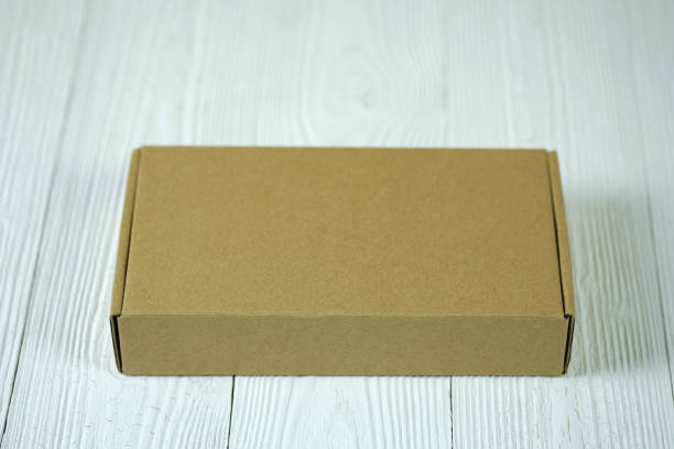 istock Empty Package brown cardboard box or tray on bright wooden table with copy space. 919520770