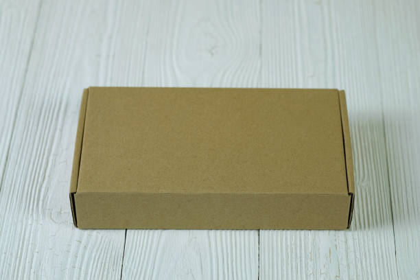 istock Empty Package brown cardboard box or tray on bright wooden table with copy space. 919520798