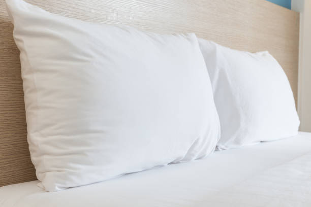 istock White bedding sheets and pillow in hotel room 919533442