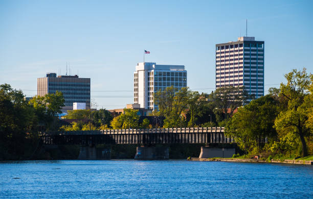 South Bend Skyline with River South Bend, Indiana skyline with the Saint Joseph River and a bridge in the foreground. south bend stock pictures, royalty-free photos & images