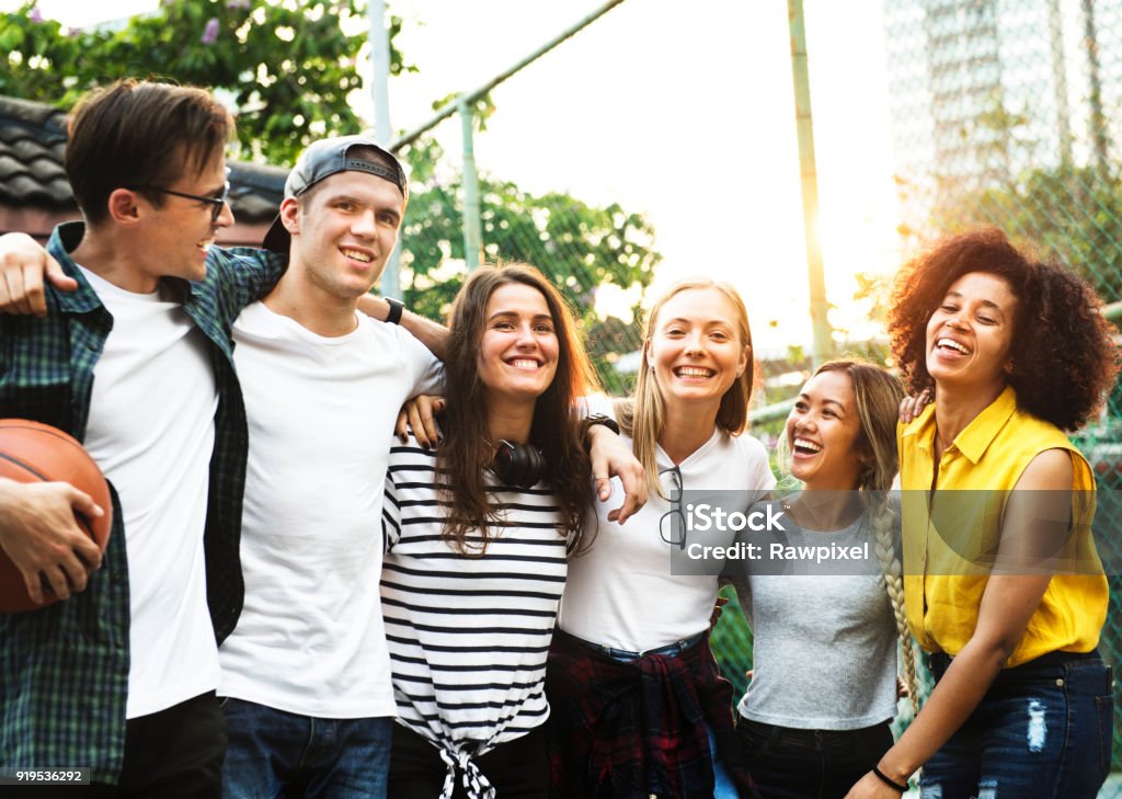 Smiling happy young adult friends arms around shoulder outdoors friendship and connection concept Teenager Stock Photo