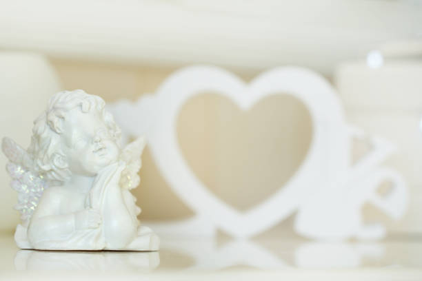 Valentine Day concept. Statuettes of small angels  over light background
