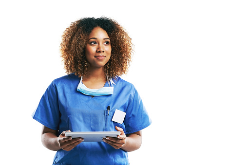 Studio shot of an attractive young nurse using a digital tablet against a white background