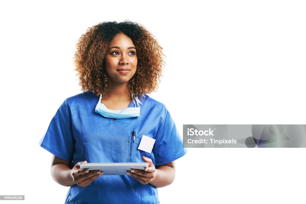 She's a gifted medical professional Studio shot of an attractive young nurse using a digital tablet against a white background Nurse Stock Photo