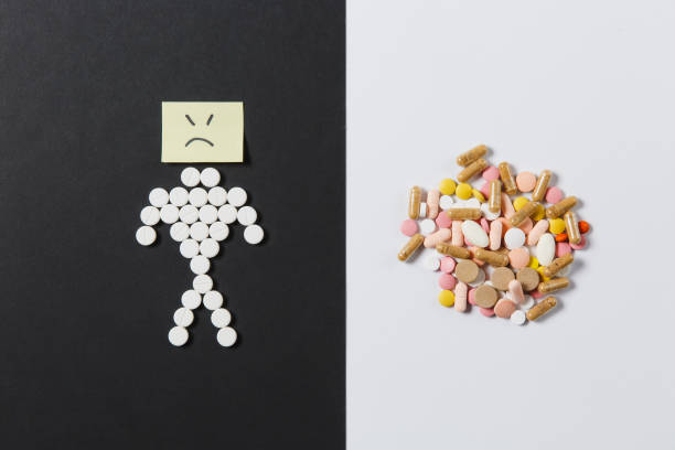 istock Medication white colorful round tablets arranged abstract on white black background. Human sad, aspirin, capsule pills design. Treatment choice healthy lifestyle concept. Copy space for advertisement. 919539454