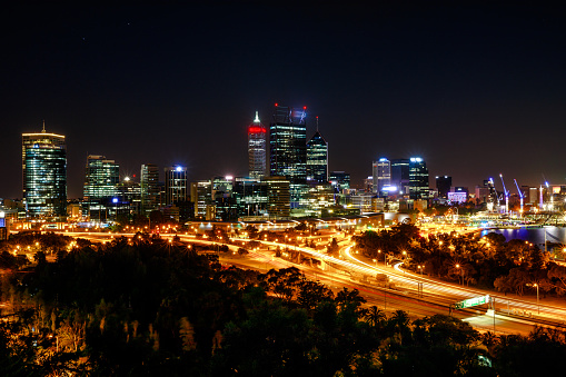 Panoramic view from King's Park near War Memorial of Perth Skyline with skyscrapers and light trails of traffic and Swan River. This overlooks is a famous landmark in Perth, Western Australia.