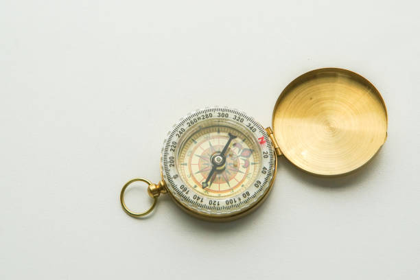 方向の分離の黄金の羅針盤 - compass direction east gold ストックフォトと画像