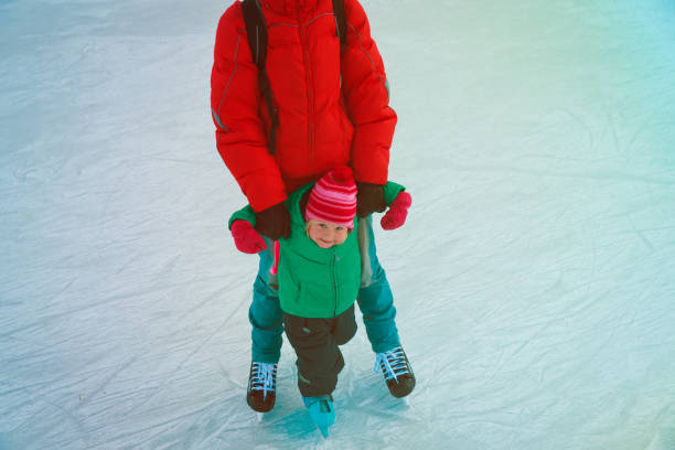 istock father and little daughter learning to skate in winter 919551340