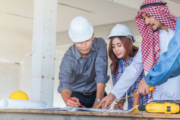 istock Group of engineer and arabian checking the blueprint on table and talking about construction project with commitment to success at construction site 919551996
