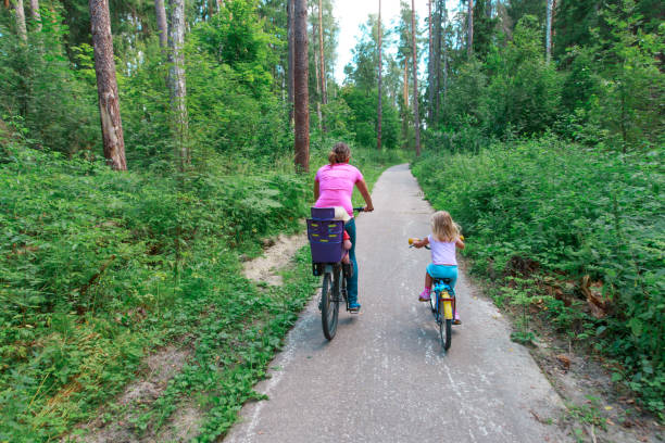 istock mother with kids riding bikes in summer nature 919554516