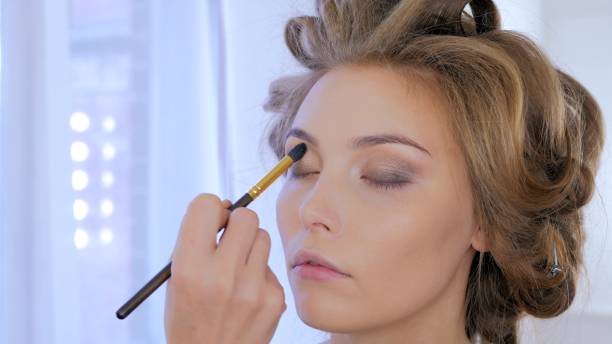 istock Professional make-up artist applying makeup on woman's face 919558284