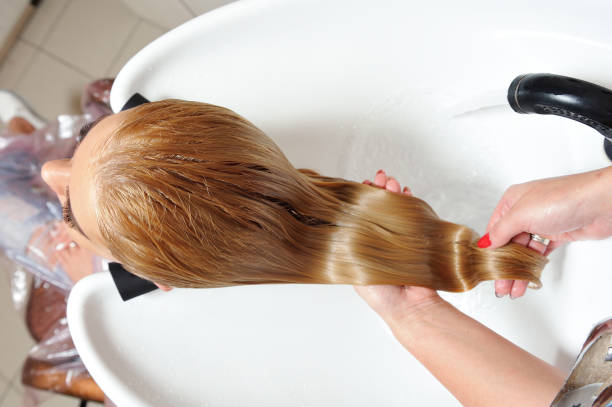 The girl washes her hair in a hairdresser, after painting her hair. stock photo