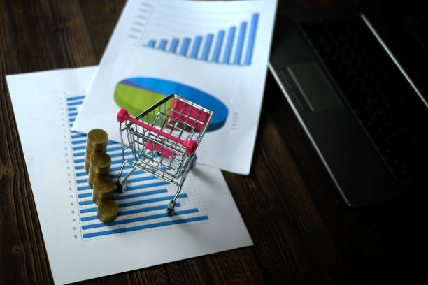 istock Step of coins stacks with trolley and notebook laptop computer and financial graph on paper on working table, business planning vision and finance analysis concept. 919567474