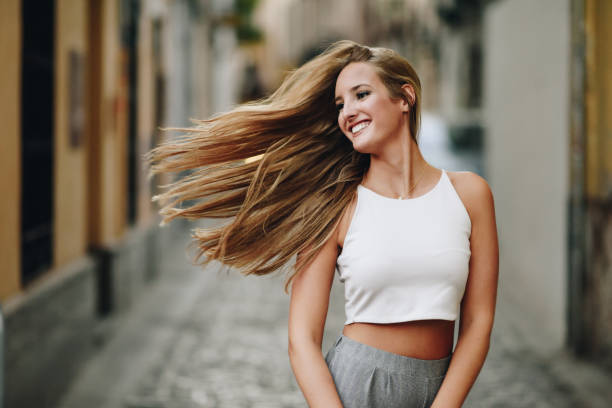 도시 배경에서 머리를 이동 행복 한 젊은 여자. - long hair fashion model women blond hair 뉴스 사진 이미지