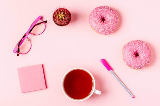 istock Cup of tea with donuts on a pink pastel background 919576654
