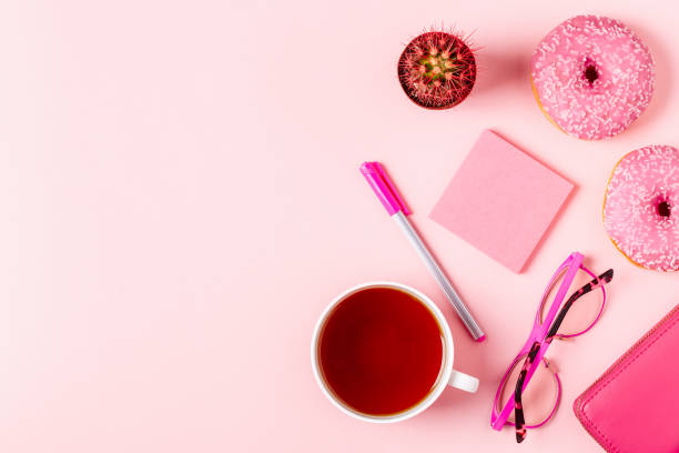 istock Cup of tea with donuts on a pink pastel background 919576688