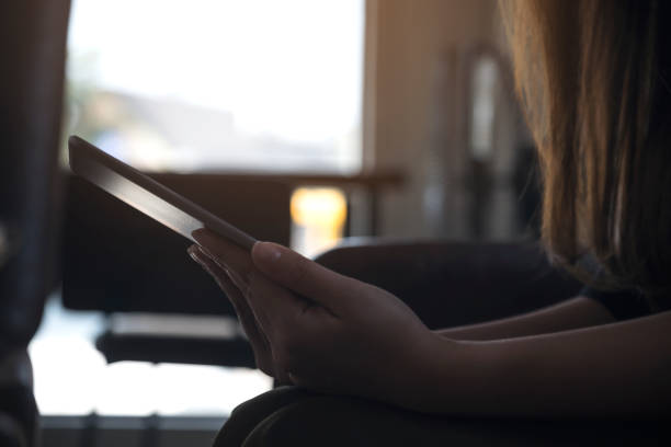 istock Closeup image of a woman holding and using tablet pc with blur background 919577254