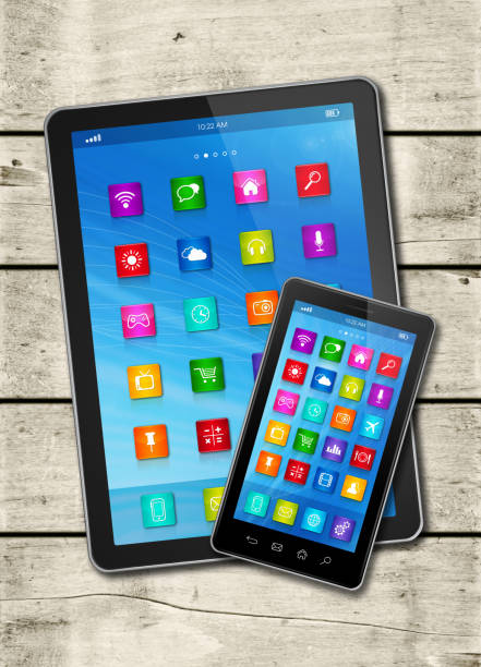 istock Smartphone and digital tablet PC with desktop icons on a white wood table 919583356