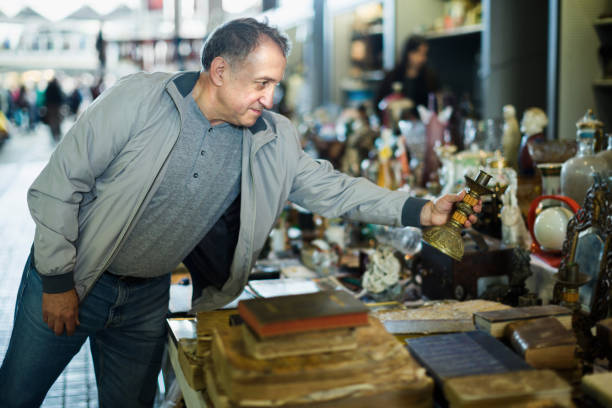 istock Senior man choosing vintage souvenirs at flea market 919604946