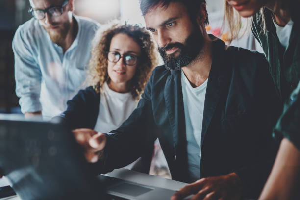 istock Group of young entrepreneurs are looking for a business solution during work process at night office.Business people meeting concept.Blurred background.Horizontal. 919632032
