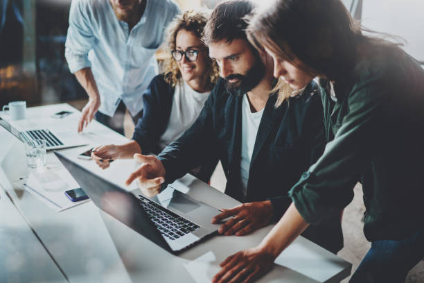 istock Working process at office.Group of young coworkers work together modern coworking studio.Young people making conversation with partners.Horizontal.Blurred background. 919632262