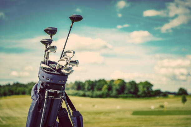 Golf equipment bag standing on a course. Golf equipment bag standing on a course. Summer sport and activity. Golf clubs close-up. golf club stock pictures, royalty-free photos & images
