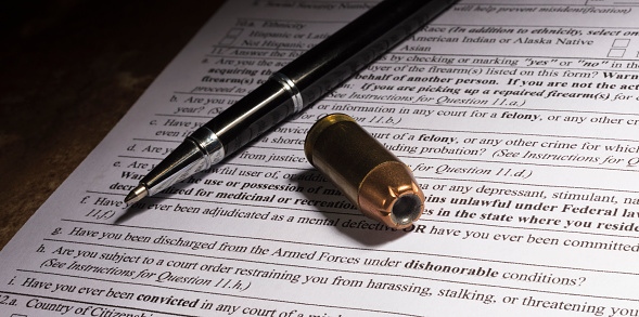 Pen and handgun cartridge on NICS background check with dishonorable discharge question