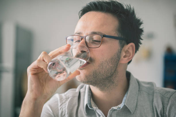 istock Young man drinking glass of water 919699238