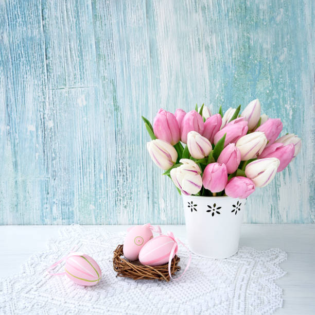 istock Easter background. Decorative Easter eggs and pink tulips in vase. Copy space 919717870