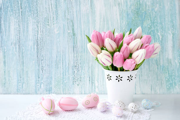 istock Easter background. Decorative Easter eggs and pink tulips in vase. Copy space 919720032
