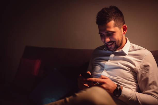 istock Young man typing on mobile late at night. 919739602