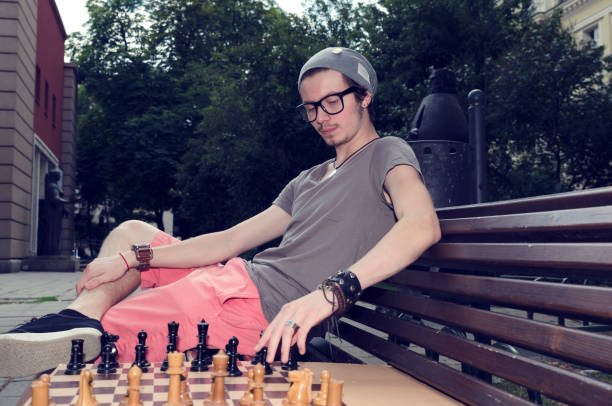 istock Young man playing chess in the park 919771232