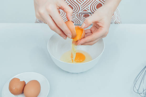 istock Close-up of female chef cracking egg 919778426