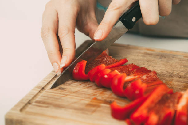 istock Female hands cutting bell pepper on board 919778490