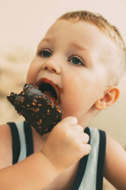 istock Little Dirty-faced Boy Biting Ice-Cream 919782422