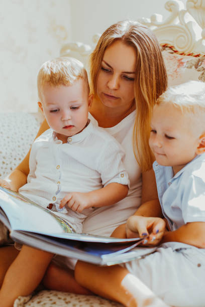 istock Mother Reading Book to Children at Home 919782434