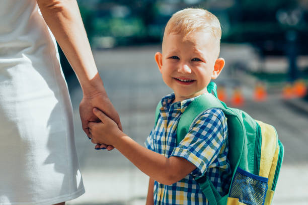 istock Smiling Schoolboy Holding Mother Hand 919782460