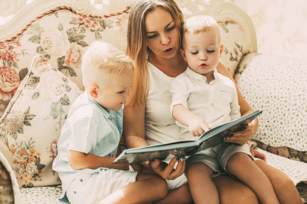 istock Mother Reading Book to Children on Sofa 919782474