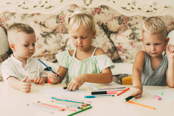 istock Three Serious Little Children Drawing at Home 919782480