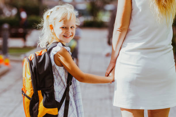 istock Smiling Schoolgirl Holding Mother Hand 919782486