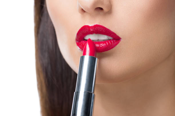 istock young woman applying lipstick 919786060