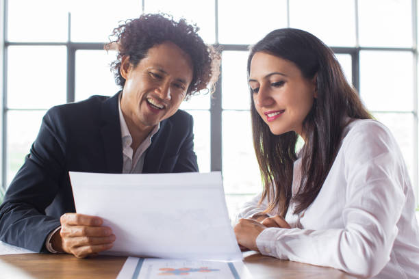 istock Cheerful man showing document to coworker 919788910